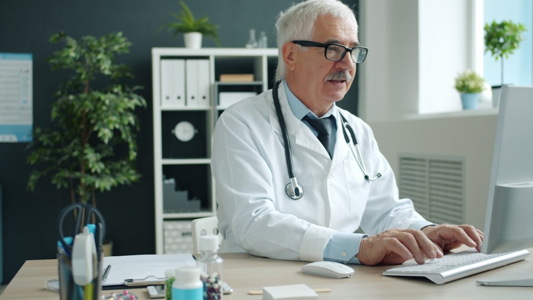 A clinician reviewing patient data on a tablet in a calm, modern hospital setting