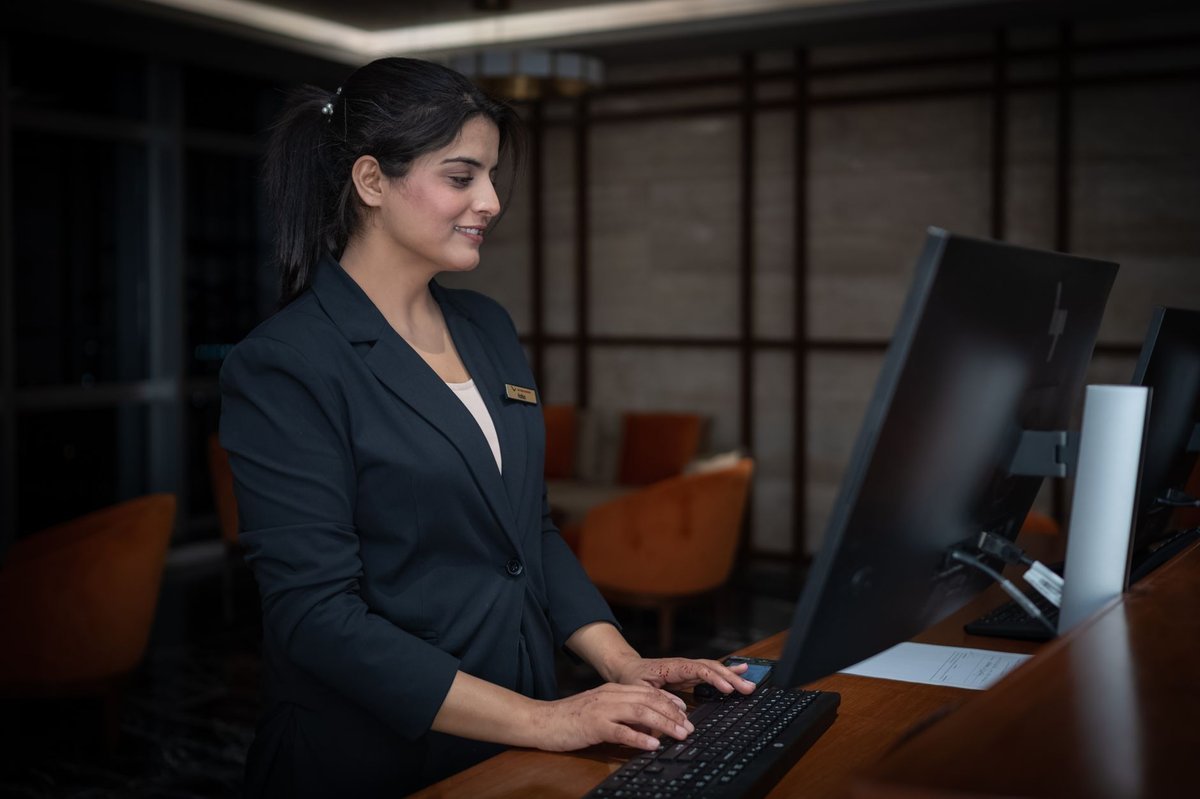 Hotel reception desk with monitors and a duty manager on shift