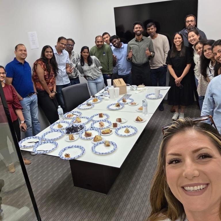 Scadea team gathered around a table for a celebration