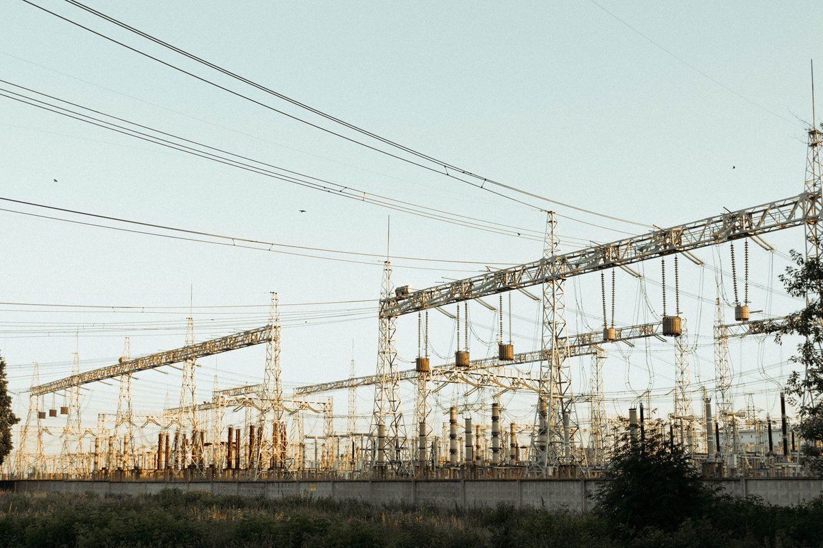 High-voltage substation and transmission lines at dusk