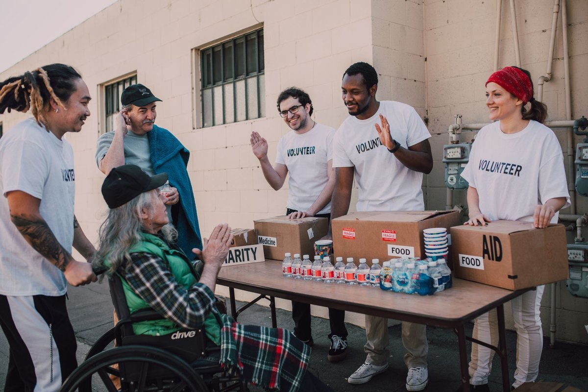 Volunteers handing out food and supplies at a community aid table