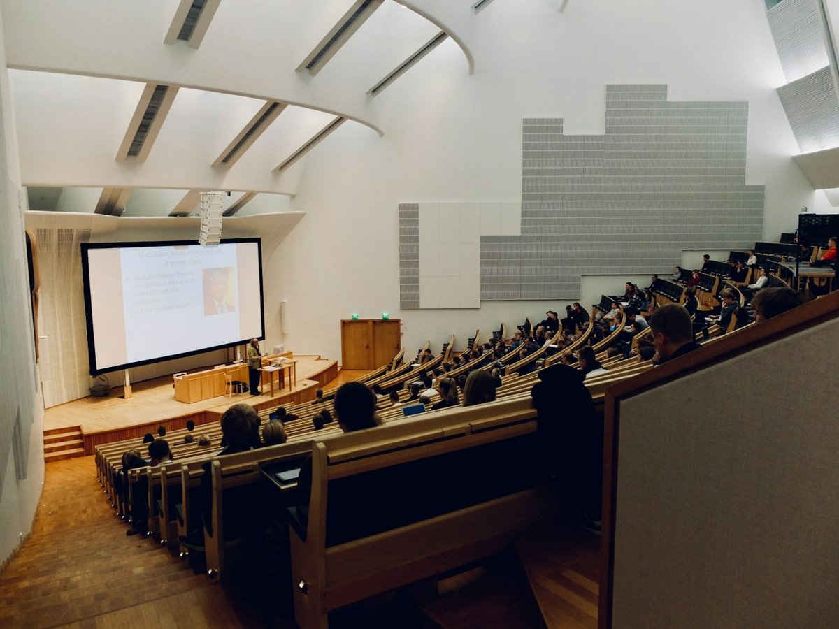 Lecture theatre with students seated and a presentation on screen