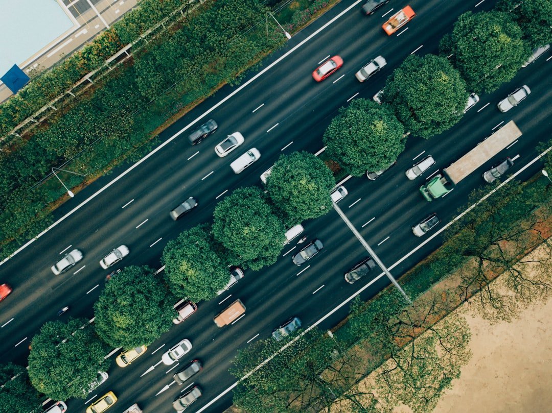 Aerial view of dense highway traffic flowing between green medians