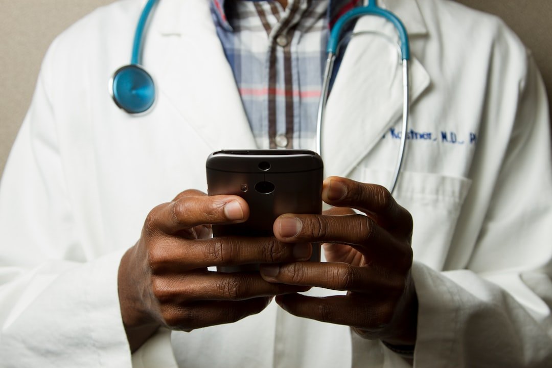 A doctor in a white coat using a smartphone
