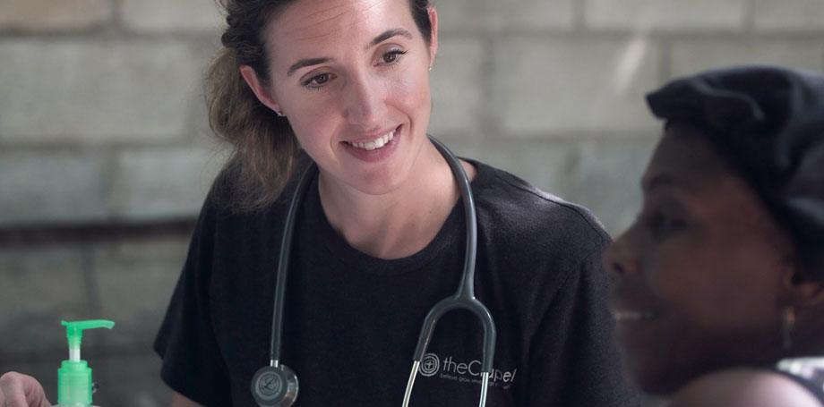 Smiling female doctor with stethoscope consulting patient.