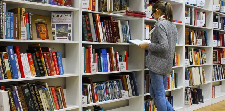 Girl reading a book in a library.