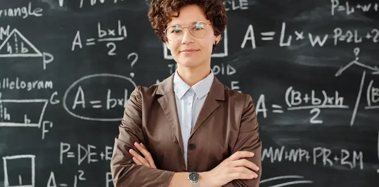 Female math teacher with equations on a blackboard.