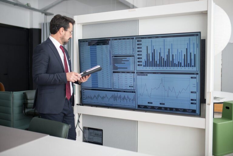 Businessman analyzing financial data on a large screen.