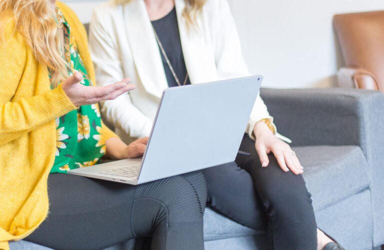 Two women collaborating on a laptop.