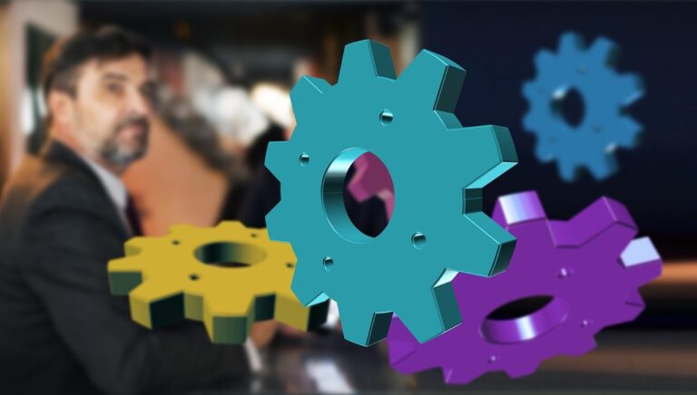 Colorful gears floating over a blurry businessman.