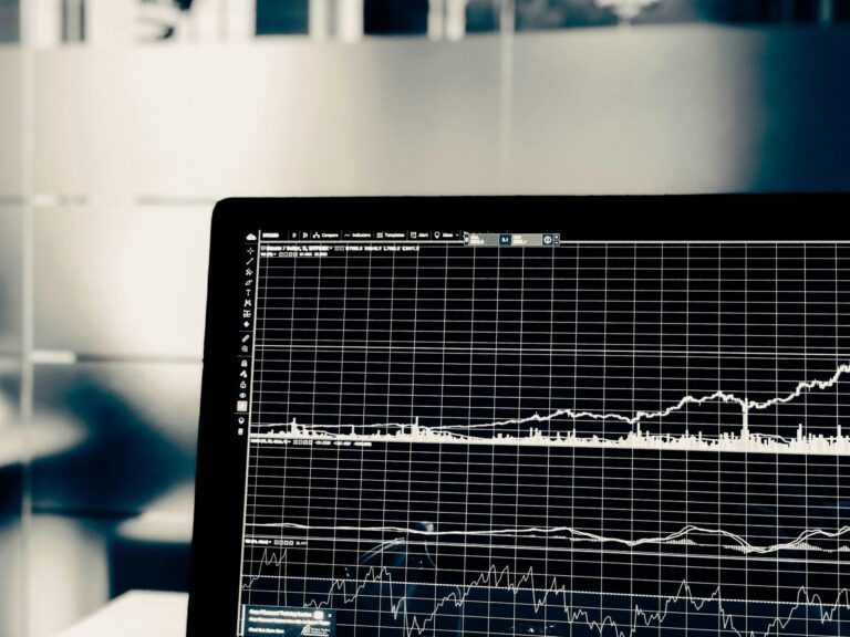 Laptop screen showing financial charts and graphs.