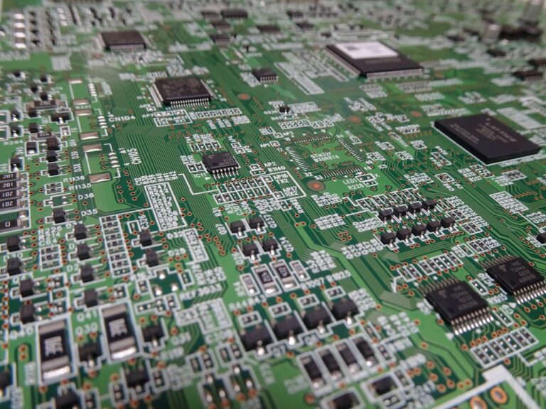 Close-up of a populated green printed circuit board showing surface-mount components