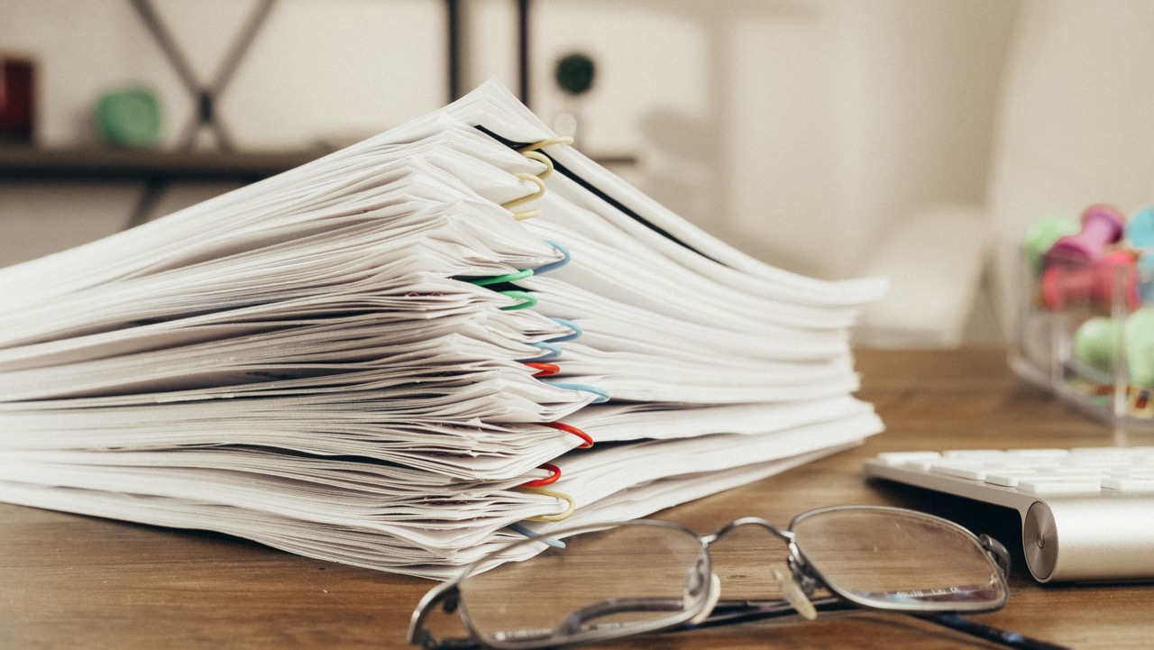 Stack of unstructured paper documents on a desk
