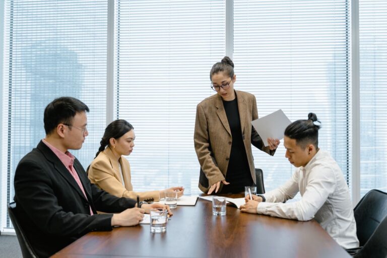 Business team meeting around a conference table with laptops and documents