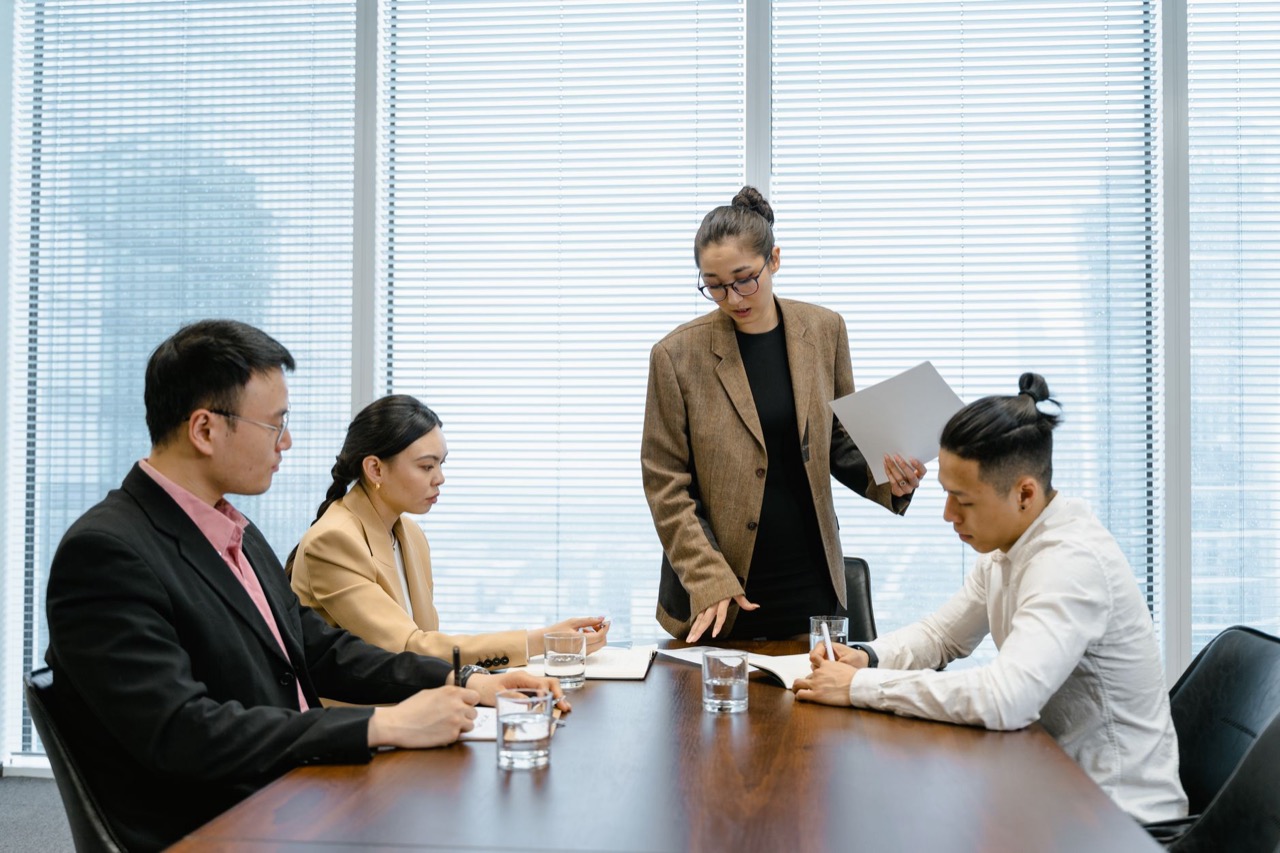 Business team meeting around a conference table with laptops and documents